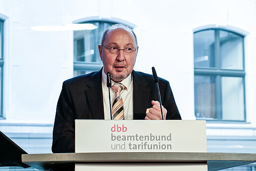 Ein Mann steht an einem Rednerpult und spricht in ein Mikrofon. Es handelt sich um Heini Schmitt, neuer dbb Fachvorstand Beamtenpolitik