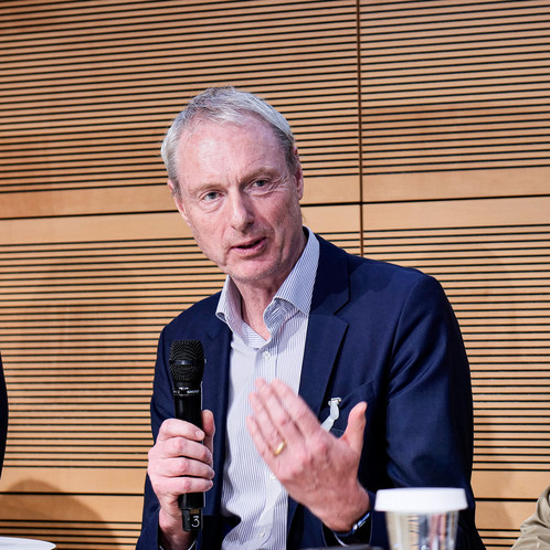 Ein Mann sitzt auf einer Bühne und spricht in ein Mikrofon