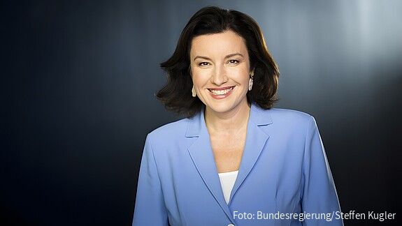 Porträt einer Frau im blauen Blazer.