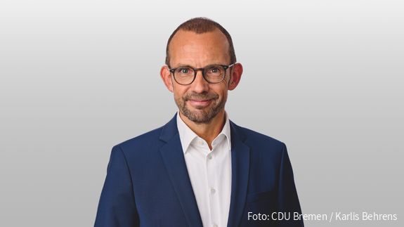 Foto von einem weißen Mann mit Anzug und Brille, der in die Kamera blickt. Es handelt sich um Thomas Röwekamp, Vorsitzender des Verteidigungsausschusses des Deutschen Bundestages