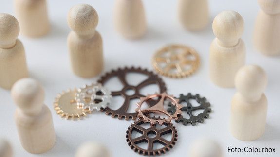 Wooden figures of people with metal gears close up. Hire personnel, team building, teamwork concept. People connection in business.