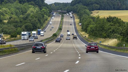 Das Foto zeigt eine dreispurige Autobahn, auf der Autos fahren.