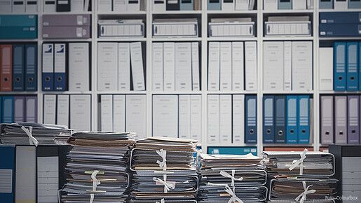 Das Foto zeigt eine Wand voll mit Aktenordnern.