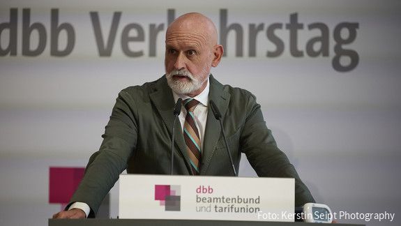 Der dbb Verkehrstag 2025 Ein Mann in Anzug steht hinter einem Rednerpult und spricht in ein Mikrofon