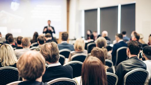 Symbolfoto zum Thema "VBLkongress": Zu sehen sind Menschen in einem Saal, die an einer Tagung teilnehmen.