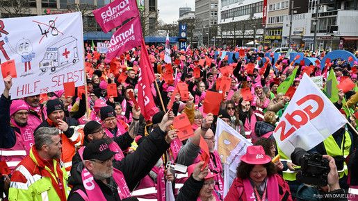 Eine Menschenmenge in bunten Warnwesten und Fahnen