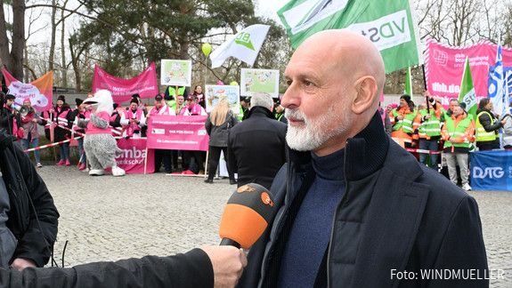Das Foto zeigt Impressionen von der Demonstration in Potsdam vor Beginn der dritten Verhandlungsrunde am 14.3.2025: Zu sehen sind Demonstrierende mit Fahnen und Plakaten sowie Vertreter der Gewerkschaften, die Reden halten.