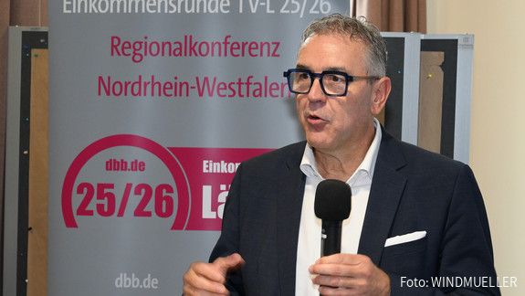 Das Foto zeigt dbb-Vize Andreas Hemsing während seiner Rede. Er hält ein Mikrofon in der Hand.