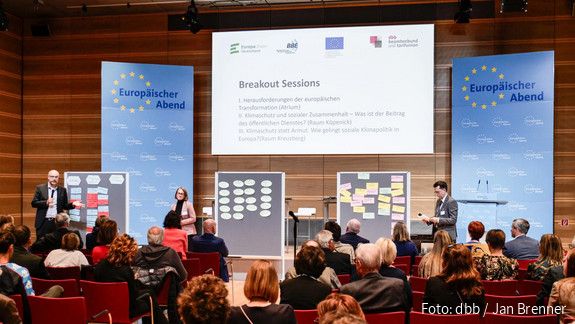 Auf der Bühne stellen die drei Leiterinnen und Leiter die Ergebnisse der Workshops vor